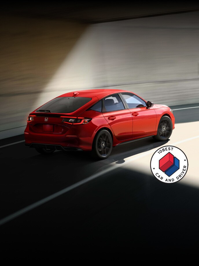 2026 Honda Civic Hatchback Sport in Rallye Red back driving through a sunlit concrete tunnel (Compact Hatchback).