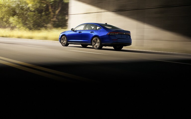 2026 Honda Accord Sport Hybrid in Still Night Pearl rear 3/4 exiting a tunnel (Mid-Size Sedan).