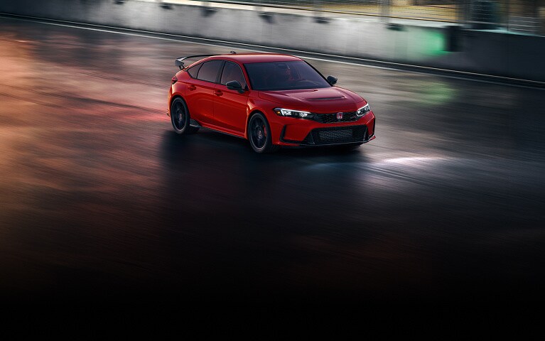 2026 Honda Civic Type R in Rallye Red front 3/4 drinving on a road at night (High-Performance Hatchback).