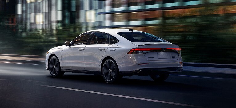 Platinum White Pearl色2026 Honda Accord Sport Hybrid後方視角,行駛在黑暗的街道上(中型轎車)。 Platinum White Pearl色2026 Honda Accord Sport Hybrid後方視角,行駛在黑暗的街道上(中型轎車)。