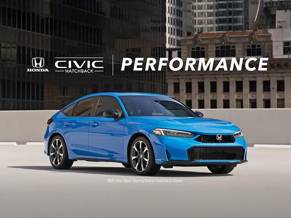 2026 Honda Civic Hatchback Sport Touring Hybrid in Boost Blue Pearl profile on a rooftop parking lot with city buildings (Compact Hatchback).