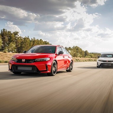2026 Honda Civic Type R in Rallye Red and Championship White driving on a highway