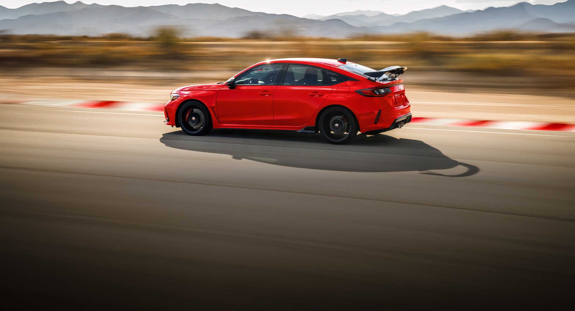 2026 Honda Civic Type R in Rallye red driving on a race track