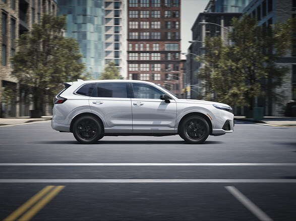 2026 CR-V e:FCEV in Platinum White Pearl parked in a clean modern urban location, with trees.
